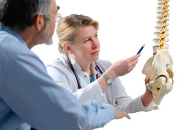 El médico aconseja al paciente sobre los signos de osteocondrosis de la columna torácica. 