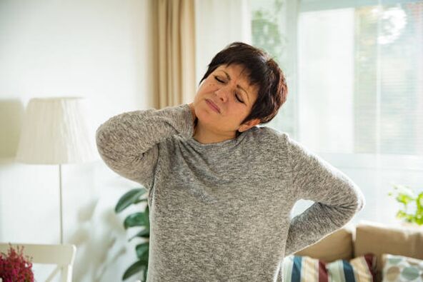 Una mujer sufre de osteocondrosis de la columna cervical.